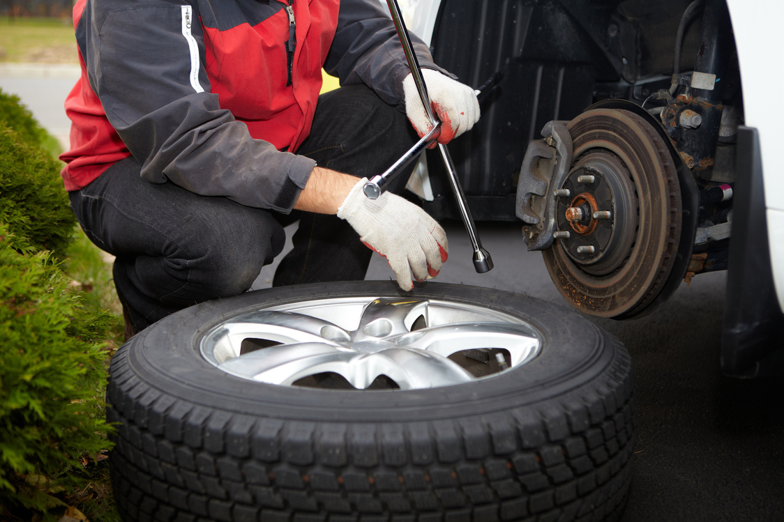 Car mechanic changing tire.